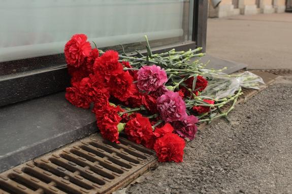 Петербуржцы несут цветы на Поцелуев мост после падения автобуса в Мойку