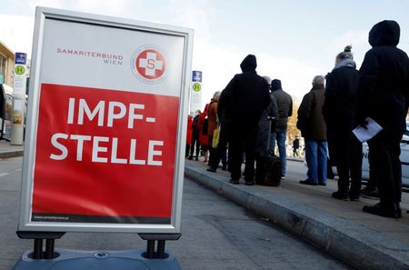 FILE PHOTO: People wait in front of a vaccination bus during the coronavirus disease (COVID-19) outbreak, as Austria's government has imposed a lockdown on people who are not fully vaccinated, in Vienna, Austria, November 18, 2021. REUTERS/Leonhard Foeger/File Photo 