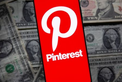 A Pinterest logo is seen on a smartphone placed over U.S. dollar banknotes in this illustration taken October 20, 2021. REUTERS/Dado Ruvic/Illustration