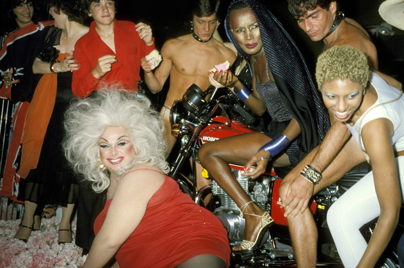 Американский актер Харрис Глен Милстед, выступающий в женском образе под псевдонимом Дивайн (слева внизу), и группа друзей празднуют день рождения Грейс Джонс (вверху справа в черном) в клубе Xenon, 1978 год Веселые, люди, эпоха