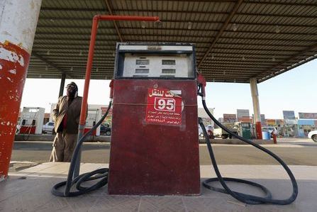 A fuel pump assistant stands next to an old fuel pump during the early hours near the village of Salwa at the Qatari-Saudi border, south of the eastern provience of Khobar, Saudi Arabia January 29, 2016. REUTERS/Hamad I Mohammed