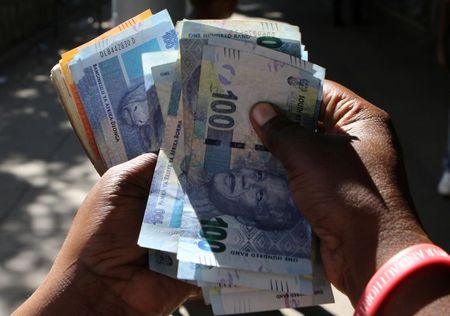 FILE PHOTO: A street money changer counts South African Rands in Harare, Zimbabwe, May 5, 2016. REUTERS/Philimon Bulawayo/File Photo