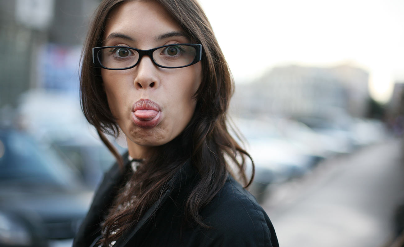 Думают я mad. Женщина с высунутым языком. Девушка в очках с высунутым языком. Показывает язык. Девушка показывает язык фото.