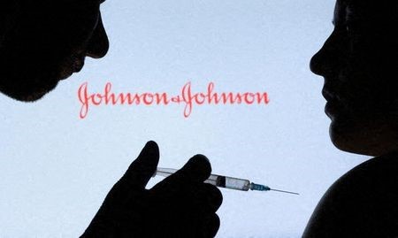 People pose with syringe with needle in front of displayed Johnson & Johnson logo in this illustration taken, December 11, 2021. REUTERS/Dado Ruvic/Illustration