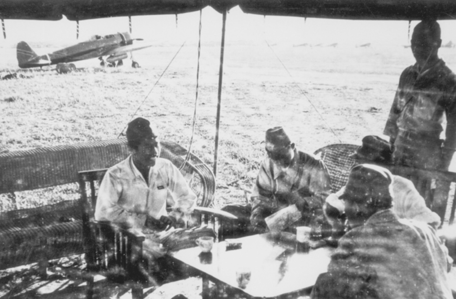 ​Авиатехники 64-го сентая на авиабазе в Малайе, начало 1942 года. На хвосте Ki-43 на заднем плане видна стрела – еще один символ 64-го сентая, использовавшийся с лета-осени 1941 года. У 1-й эскадрильи стрела была белой, у 2-й – красной, у 3-й – желтой, а у звена управления сентая – темно-синей. - Песни Warspot: Соколиная авиагруппа подполковника Като | Warspot.ru
