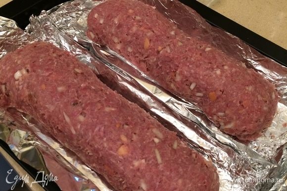 Приподнимая края пленки, свернуть аккуратно рулет, края защипать. Глубокую форму для выпечки (противень) выстелить фольгой, выложить первый рулет. То же самое сделать со второй частью фарша и начинки. Выложить в тот же противень второй рулет. Приподнимая края пленки, свернуть аккуратно рулет, края защипать. Глубокую форму для выпечки (противень) выстелить фольгой, выложить первый рулет. То же самое сделать со второй частью фарша и начинки. Выложить в тот же противень второй рулет.