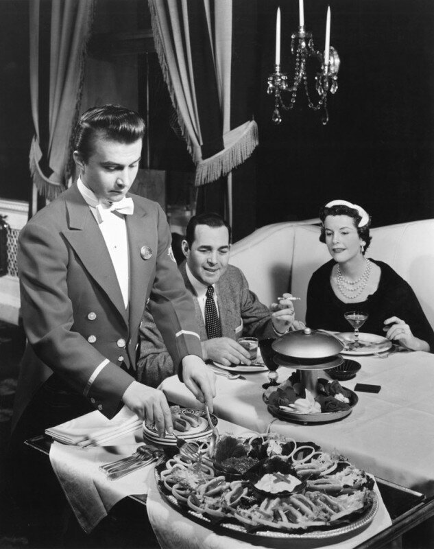 Официант подает мини хот-доги в отеле - Ambassador East Hotel в Чикаго, США. 12 апреля 1955 года. история, ретро, фото