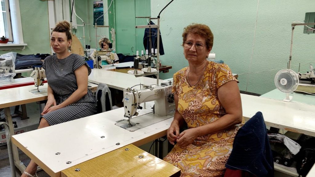 Швеи работают в мастерской с швейными машинами