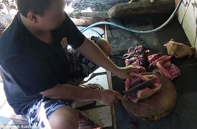 A man is seen preparing meat to be sold on the popular Indonesian island of Bali