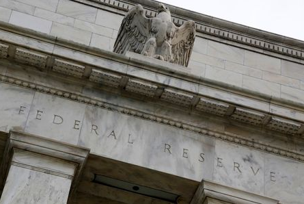 An eagle tops the U.S. Federal Reserve building's facade in Washington, July 31, 2013. The U.S. Federal Reserve likely will decide at the end of a policy meeting on Wednesday to continue buying bonds at an $85 billion monthly pace, but it could alter an accompanying statement to spell out the possibility of scaling back purchases later this year. REUTERS/Jonathan Ernst (UNITED STATES - Tags: POLITICS BUSINESS)