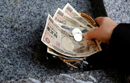 A visitor washes Japanese yen banknotes and coins in water to pray for prosperity at Koami shrine in Tokyo's Nihonbashi business district, Japan, November 13, 2017. REUTERS/Toru Hanai