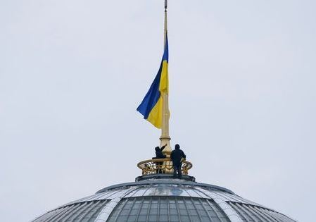Workers install the Ukrainian national flag on the roof of the parliament building in Kiev, Ukraine January 14, 2020. REUTERS/Gleb Garanich