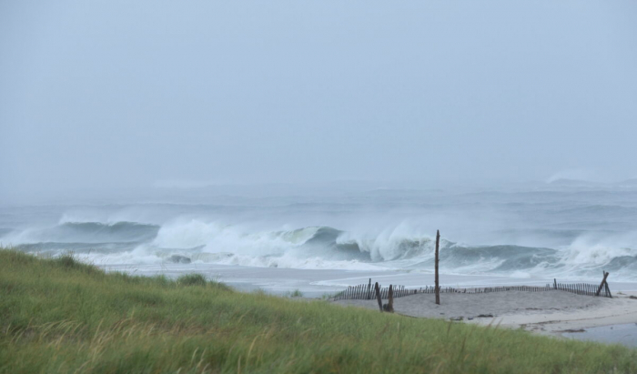 Волны обрушиваются на пляж Понкуог 22 августа 2021 г. Ураган «Генри», который теперь классифицируется как тропический шторм, приближается к побережью Лонг-Айленда