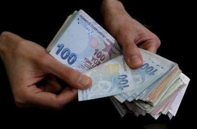 FILE PHOTO: A merchant counts Turkish lira banknotes at the Grand Bazaar in Istanbul, Turkey, March 29, 2019. REUTERS/Murad Sezer
