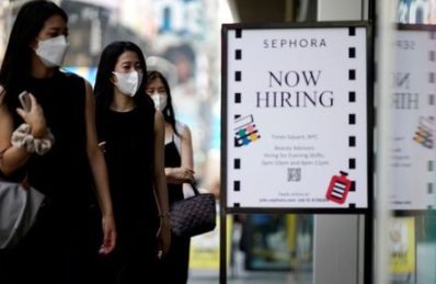 A sign advertising job openings is seen while people walk into the store in New York City, New York, U.S., August 6, 2021. REUTERS/Eduardo Munoz