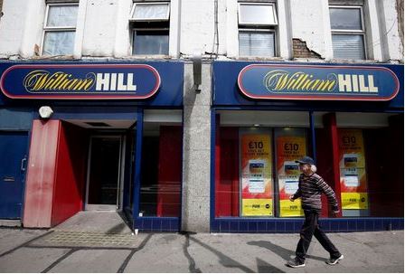 A pedestrian walks past a William Hill betting shop in London, Britain July 25, 2016. REUTERS/Neil Hall