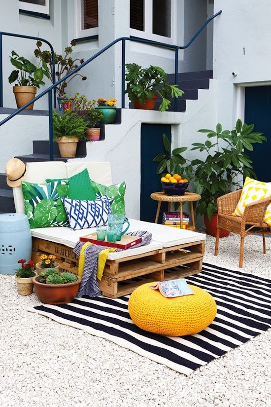  10 bold print pillows and a striped rug add cheer to this outdoor lounge