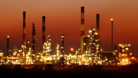 The chimneys of the Total Grandpuits oil refinery are seen just after sunset, southeast of Paris, France, March 1, 2021. REUTERS/Christian Hartmann