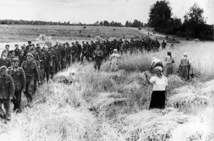 Женщина грозит кулаком пленным нацистам. СССР, 1944 год.