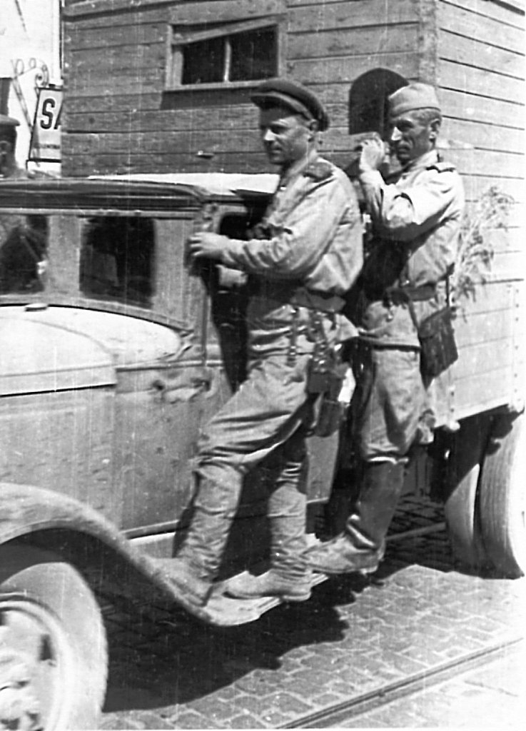 Два советских военных на подножке грузовика ГАЗ-АА на улице освобожденного Бухареста. Время съемки: 30.08.1944.