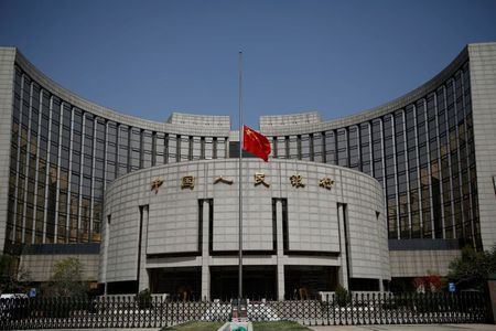 The Chinese national flag flies at half-mast at the headquarters of the People's Bank of China, the central bank (PBOC), as China holds a national mourning for those who died of the coronavirus disease (COVID-19), on the Qingming tomb-sweeping festival in Beijing, China April 4, 2020. REUTERS/Carlos Garcia Rawlins
