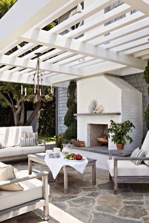  05 a coastal inspired outdoor living room with a chandelier and a fireplace and neutral upholstery