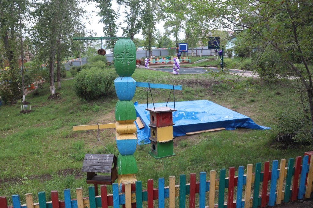 Детская площадка с разноцветными кормушками для птиц