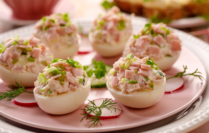 Положите в половинки яиц остатки оливье. / Фото: lifehacker.ru