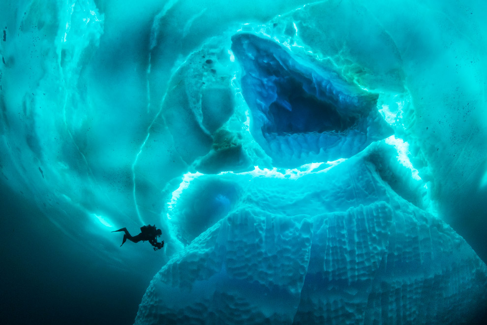 Stunning photos show ice dive beneath giant iceberg Stunning photos show ice dive beneath giant iceberg