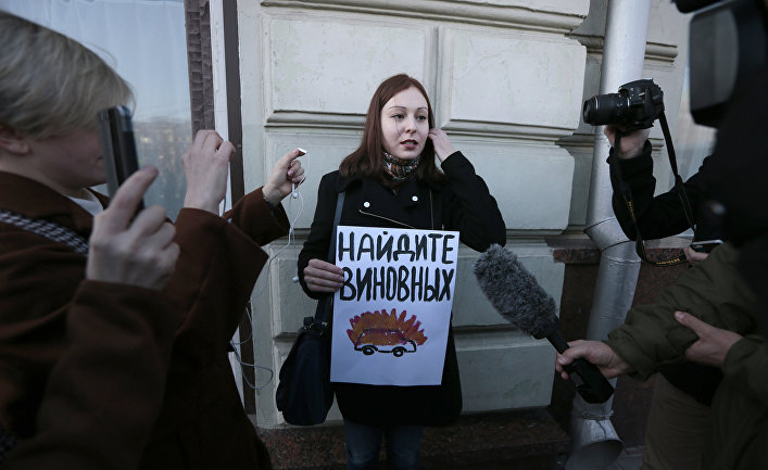 Активист отстаивающий права человека с плакатом, призывающим найти виновных в инциденте с нападением на журналистов