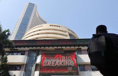 FILE PHOTO: A man looks at a screen displaying budget news, on a facade of the Bombay Stock Exchange (BSE) building in Mumbai, India, February 1, 2022. REUTERS/Francis Mascarenhas 