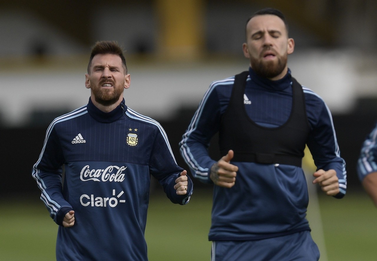 Argentina's forward Lionel Messi (L) and defender Nicolas Otamendi jog