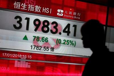 A man walks past a panel displaying the fresh closing peak Hang Seng Index in Hong Kong, China January 17, 2018. REUTERS/Bobby Yip