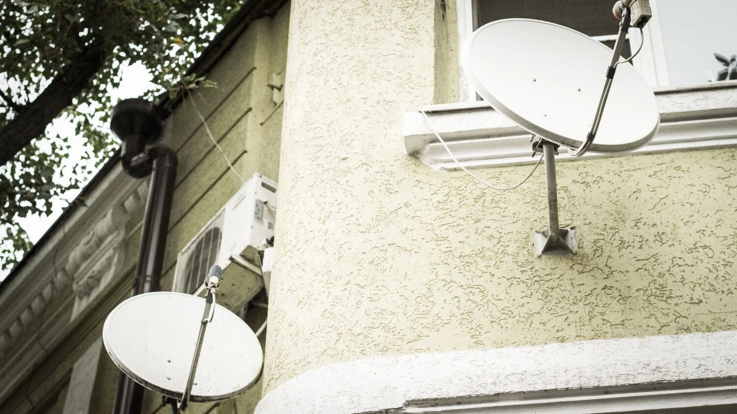 Спутниковые тарелки на стене дома