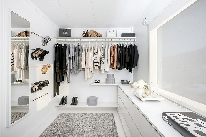 Уютная светлая комната для хранения вещей с полочками для обуви и удобными деталями интерьера.