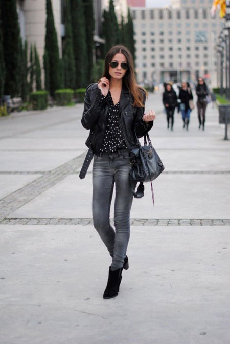 Девушка в черной блузке и серых джинсах