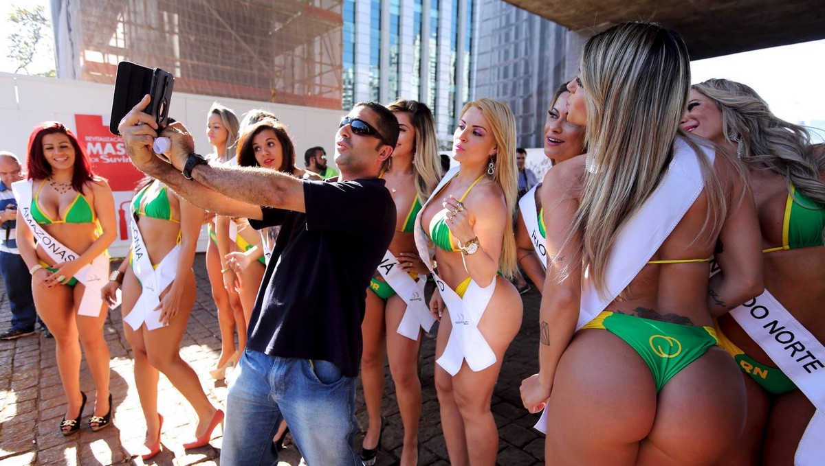A man takes a selfie with candidates of the Miss Bumbum Brazil 2015 pageant in Sao Paulo