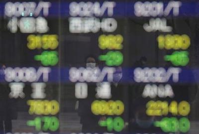 Pedestrians wearing facial masks, following the coronavirus disease (COVID-19) outbreak, are reflected on an electric board showing stock prices outside a brokerage at a business district in Tokyo, Japan, January 4, 2021. REUTERS/Kim Kyung-Hoon