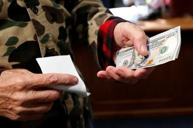 66-year-old Republican Eric Merrill of New Boston, New Hampshire, holds 1000 dollars in cash to file declaration of candidacy papers with New Hampshire Secretary of State Bill Gardner to appear on the 2020 New Hampshire presidential primary election ballot at the State House in Concord, New Hampshire, U.S., November 8, 2019. REUTERS/Mike Segar 