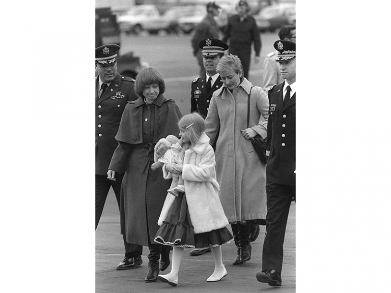 На фото: Карин Николсон с 8-летней дочерью Дженни идут по взлетно-посадочной полосе к самолету ВВС США с телом майора США Артура Д. Николсона-младшего перед вылетом в Соединенные Штаты в аэропорту Франкфурта, Западная Германия, Рейн-Майн, 1985 год.