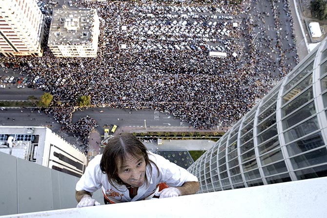 Abu Dhabi, UNITED ARAB EMIRATES: French "Spiderman" Alain Robert climbs the Abu Dhabi Investment Authority building in Abu Dhabi, 23 February 2007. While other famous urban climbers sometimes used clamps or suction cups, Robert uses no tools or safety devices of any kind. Using only his bare hands and climbing shoes, Robert has scaled more than 70 giant structures around the globe including many of the world's tallest structures. AFP PHOTO/STR (Photo credit should read -/AFP/Getty Images)