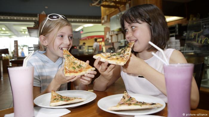 Две девочки едят пиццу