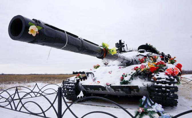 Подбитый танк ополчения на подъезде к Луганску. Машину обнесли оградкой, выкрасили, уложили венками - сделали памятник