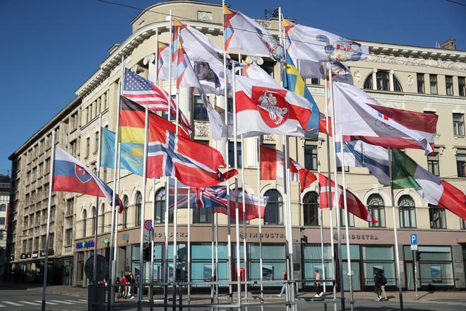 Бело-красно-белый флаг (в центре), которым был заменен флаг Белоруссии, вывешенный около гостиницы Radisson Blu Hotel Latvija 