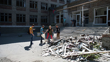 Жители Горловки убирают территорию школы № 16, пострадавшей от ночного обстрела