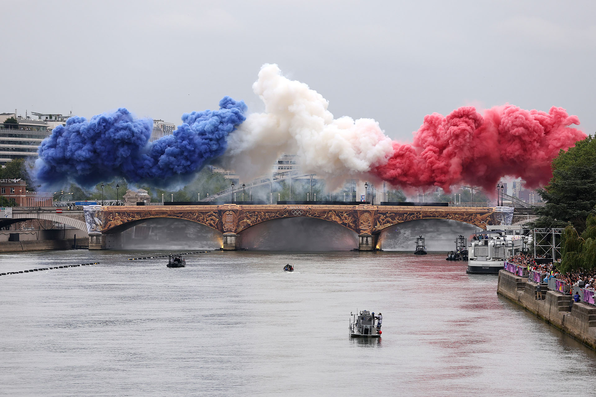 Дым, символизирующий флаг Франции, над мостом Аустерлиц во время церемонии открытия Олимпийских игр в Париже, 26 июля 2024 года