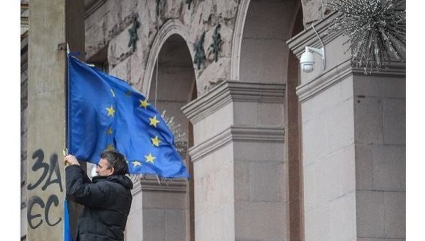 Участник акций за евроинтеграцию Украины закрепляет флаг ЕС