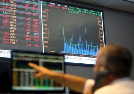 A man points to an electronic board showing the graph of the recent fluctuations of market indices at the floor of Brazil's BM&F Bovespa Stock Market in downtown Sao Paulo, Brazil, January 7, 2016. Latin American currencies weakened on Thursday after China allowed the yuan to drop further, sparking fears of wider economic weakness in the world's top consumer of commodities. REUTERS/Paulo Whitaker