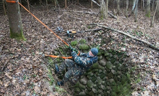 Тайник в лесу: черный копатель спустился в яму под камнем