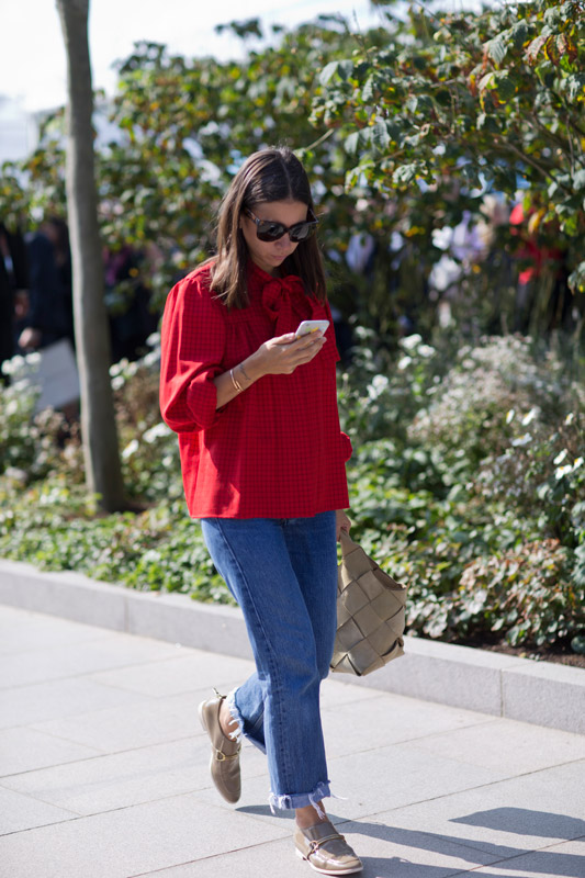 Девушка в красной блузе с бантом и широких джинсах, бежевые туфли и сумка